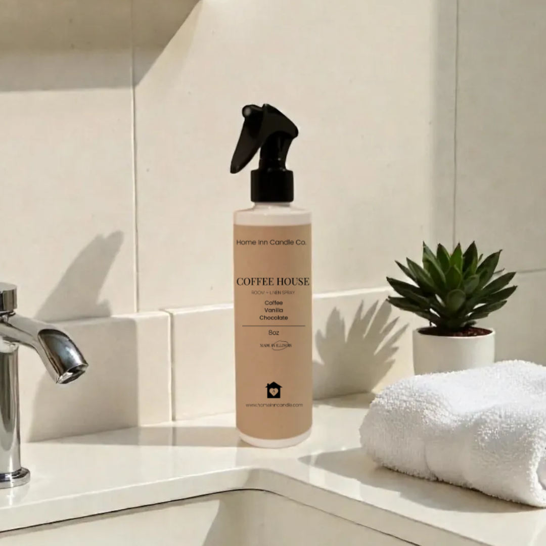 Bottle of home inn candle room spray on a bathroom counter with sink and towel in the background