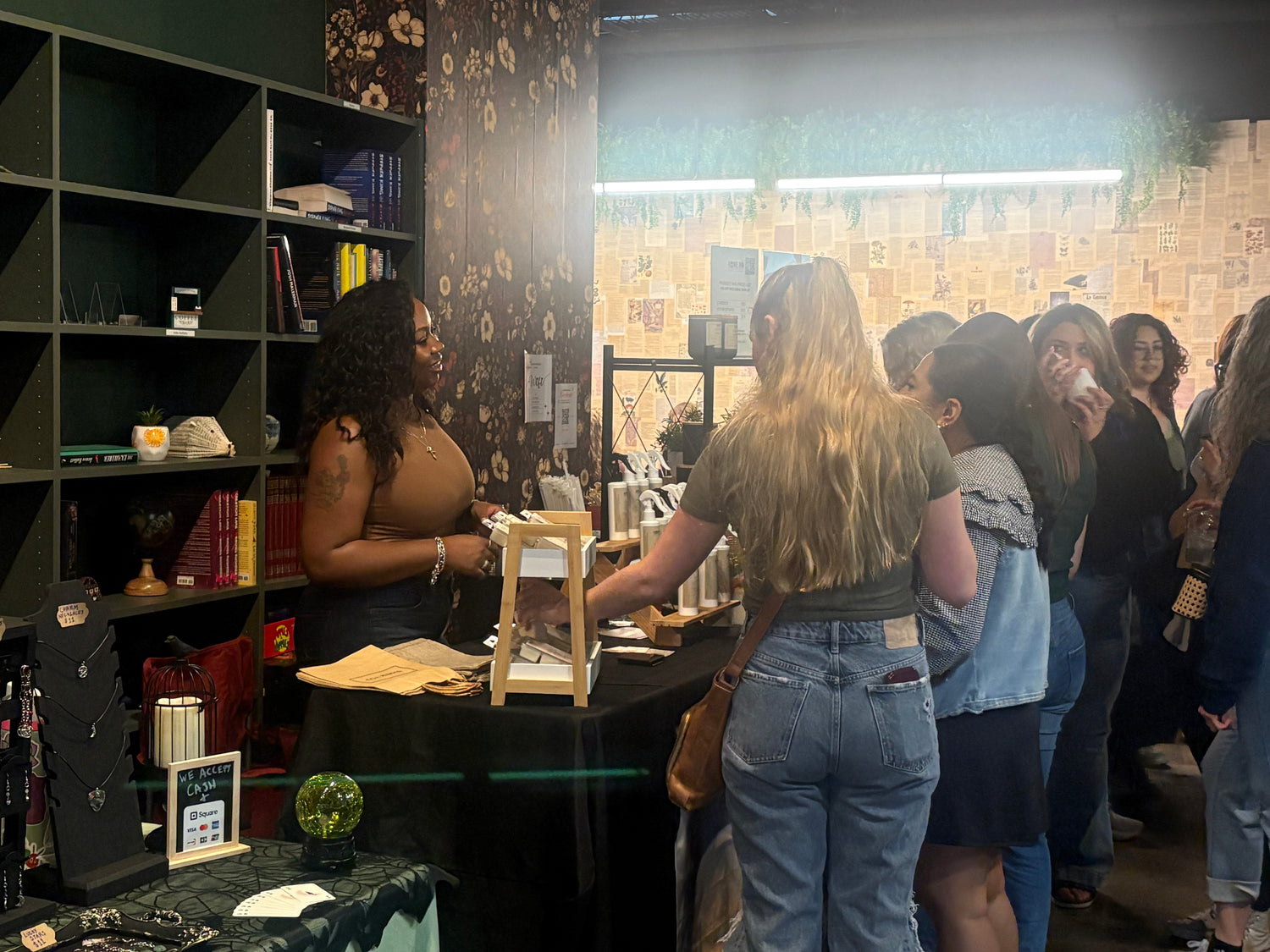 Woman interacting with a display at a store, surrounded by other people.