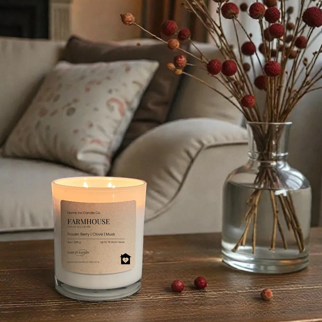 Candle with a label on a wooden table in a cozy living room setting.