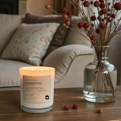 Candle with a label on a wooden table in a cozy living room setting.