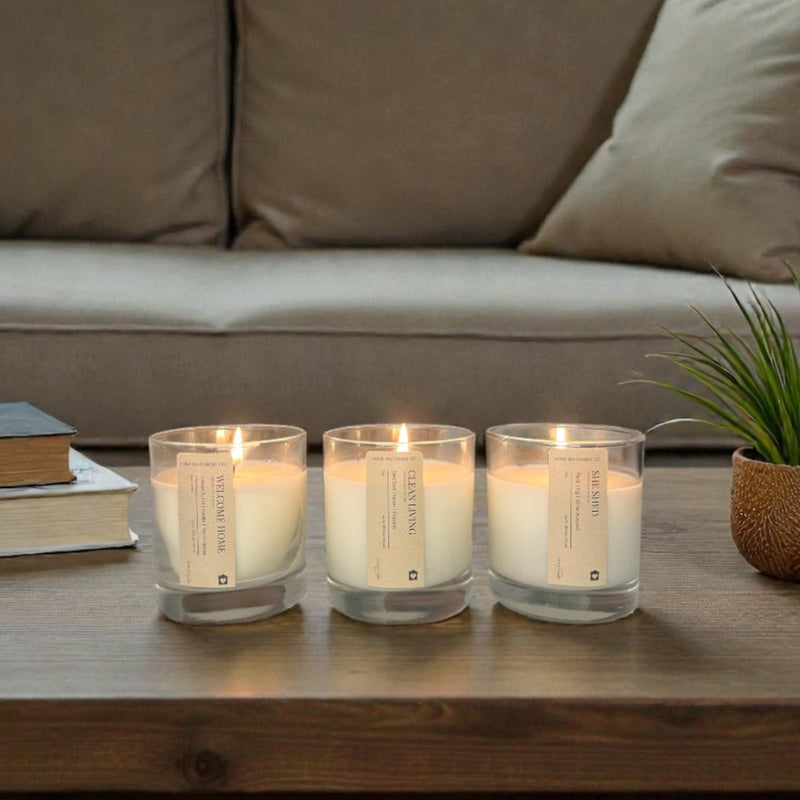 Candles on a wooden coffee table in front of a beige sofa with a window in the background