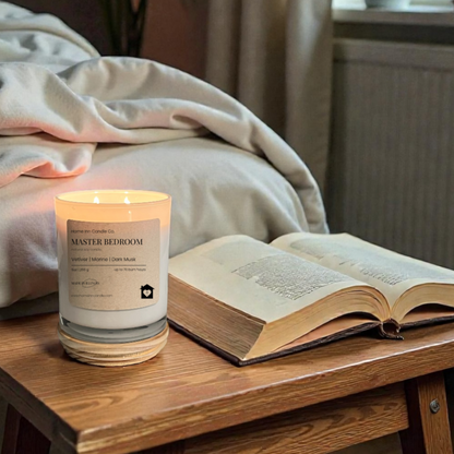 Candle and open book on a wooden table with a cozy room setting.