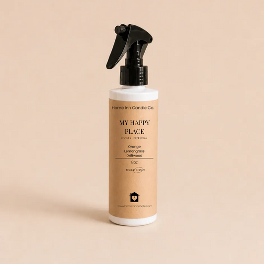 A bottle of My Happy Place Room spray from Home Inn Candle with a black trigger sprayer and a beige label, set against a solid beige background.