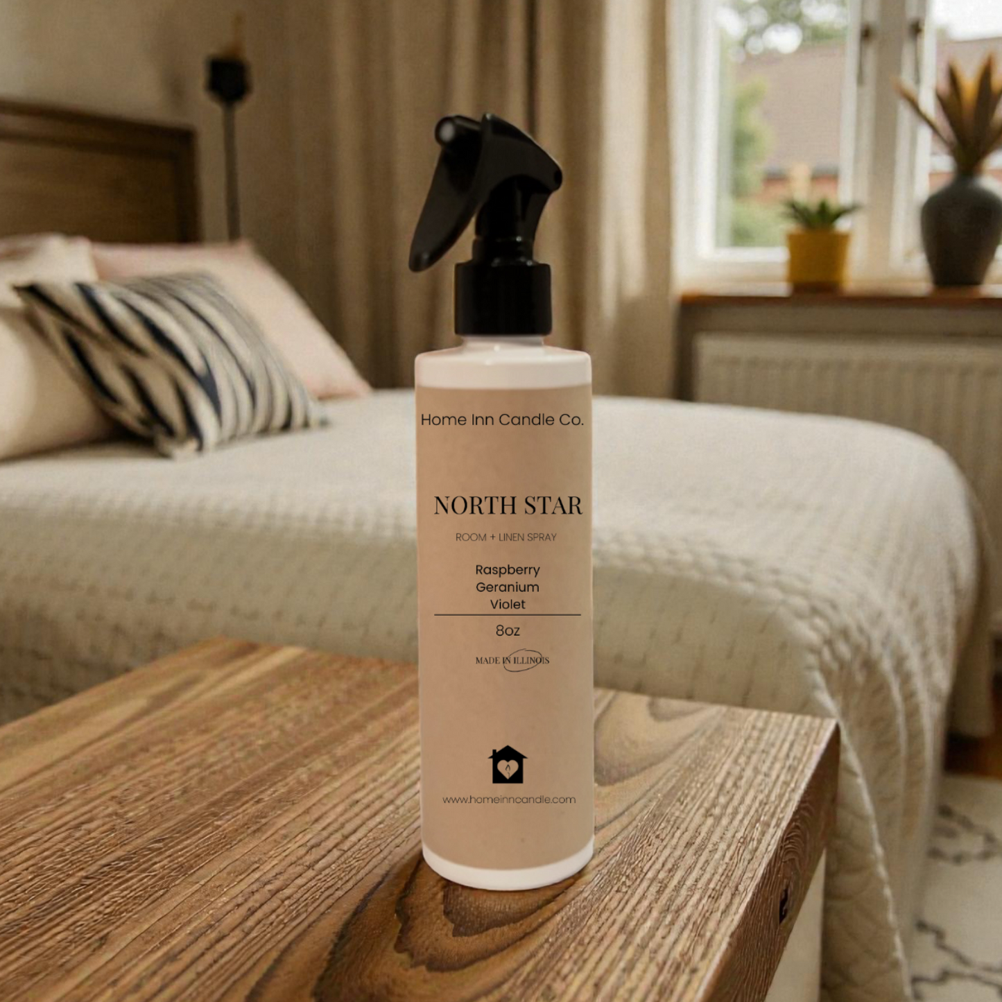 Bottle of Home Inn Candle 'North Star' room spray on a wooden surface with a bedroom in the background