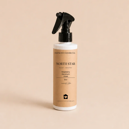 A bottle of North Star Room spray from Home Inn Candle with a black trigger sprayer and a beige label, set against a solid beige background.