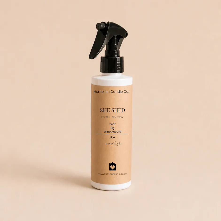 A bottle of She Shed Room spray from Home Inn Candle with a black trigger sprayer and a beige label, set against a solid beige background.