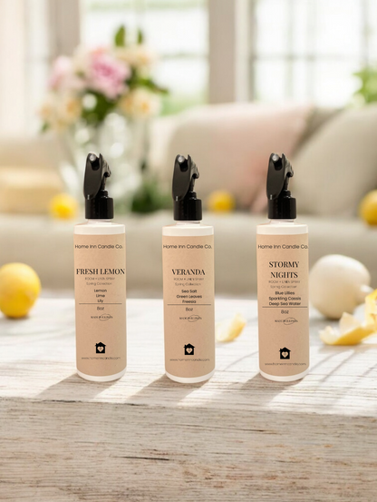 Three bottles of room sprays labeled Fresh Lemon, Veranda and Stormy Nights from Home Inn Candle Co Spring Room Spray collection with spring decor
