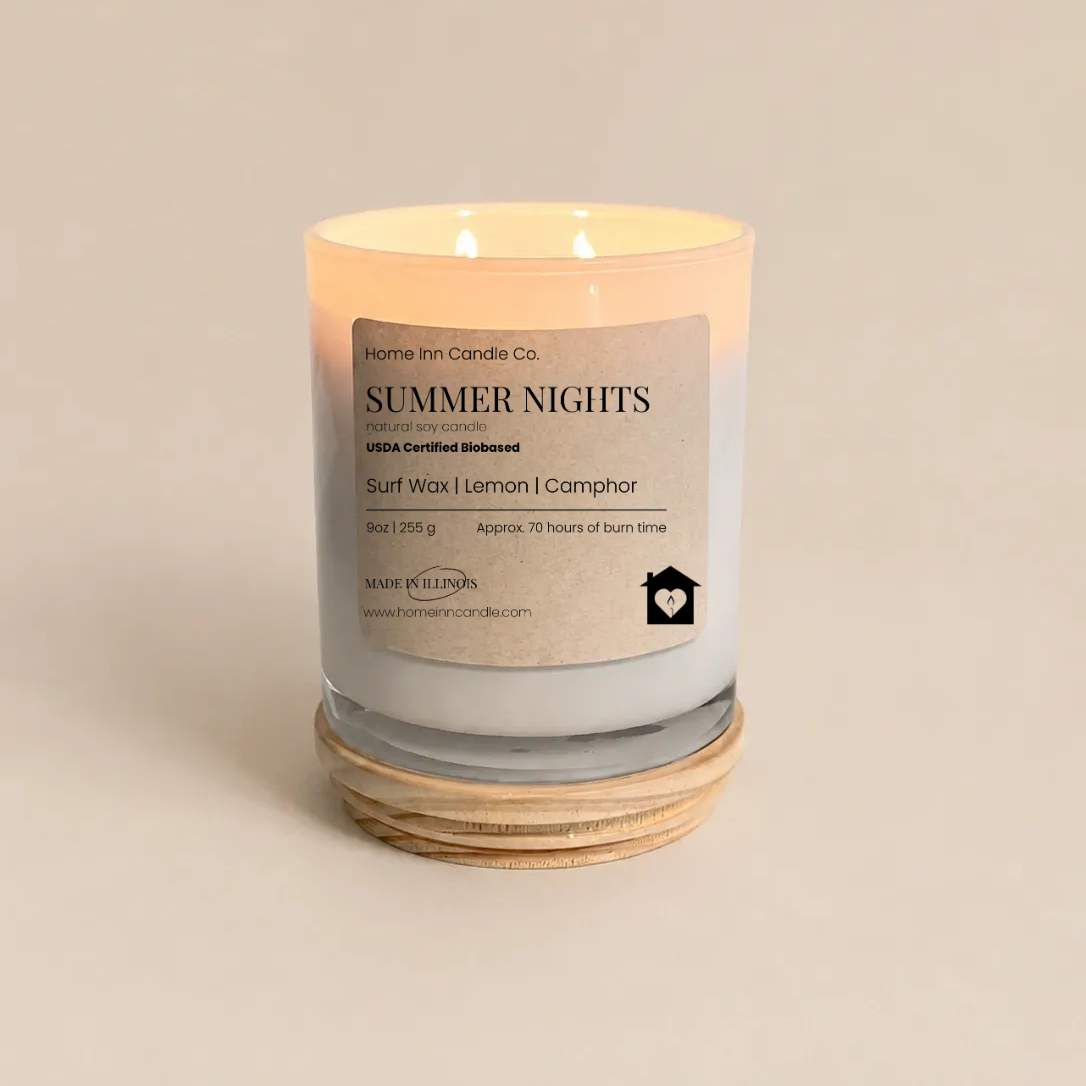 A lit scented candle in a clear glass jar with a cream-colored label reading 'Summer Nights' from Home Inn Candle