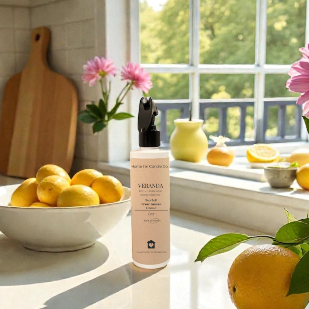 Kitchen counter with lemons, a Veranda Room Spray from Home Inn Candle Co and flowers on a sunny day.