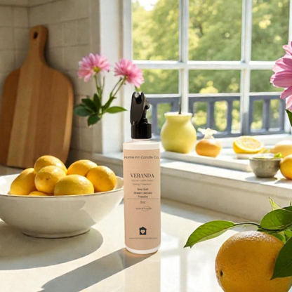 Kitchen counter with lemons, a Veranda Room Spray from Home Inn Candle Co and flowers on a sunny day.