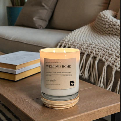 Candle labeled 'Welcome Home' on a coffee table in a cozy living room.