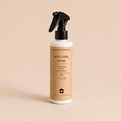 A bottle of Welcome Home Room spray from Home Inn Candle with a black trigger sprayer and a beige label, set against a solid beige background.
